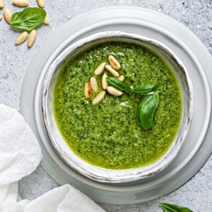 basil pesto sauce in a white bowl on a white table