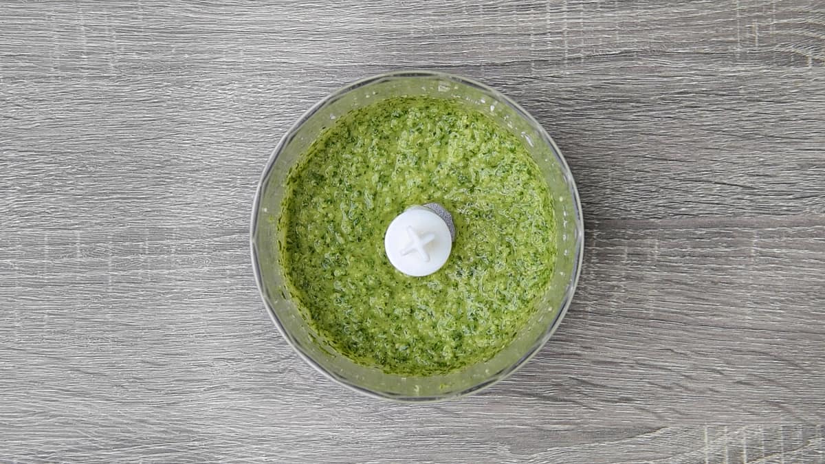 finished basil pesto sauce in the bowl of a immersion blender chopper bowl