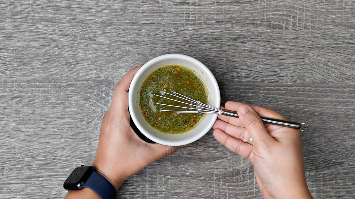 hand using small whisk to make lime dill vinaigrette