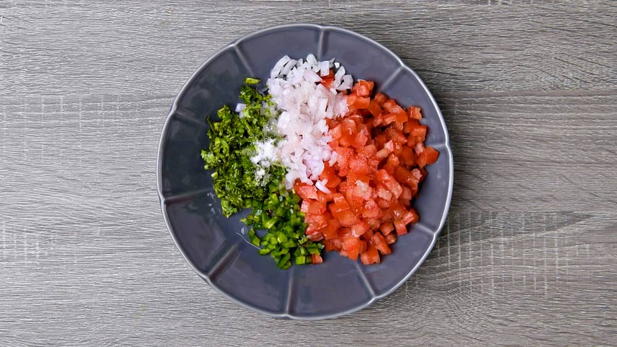 all ingredients for pico de gallo added to a mixing bowl