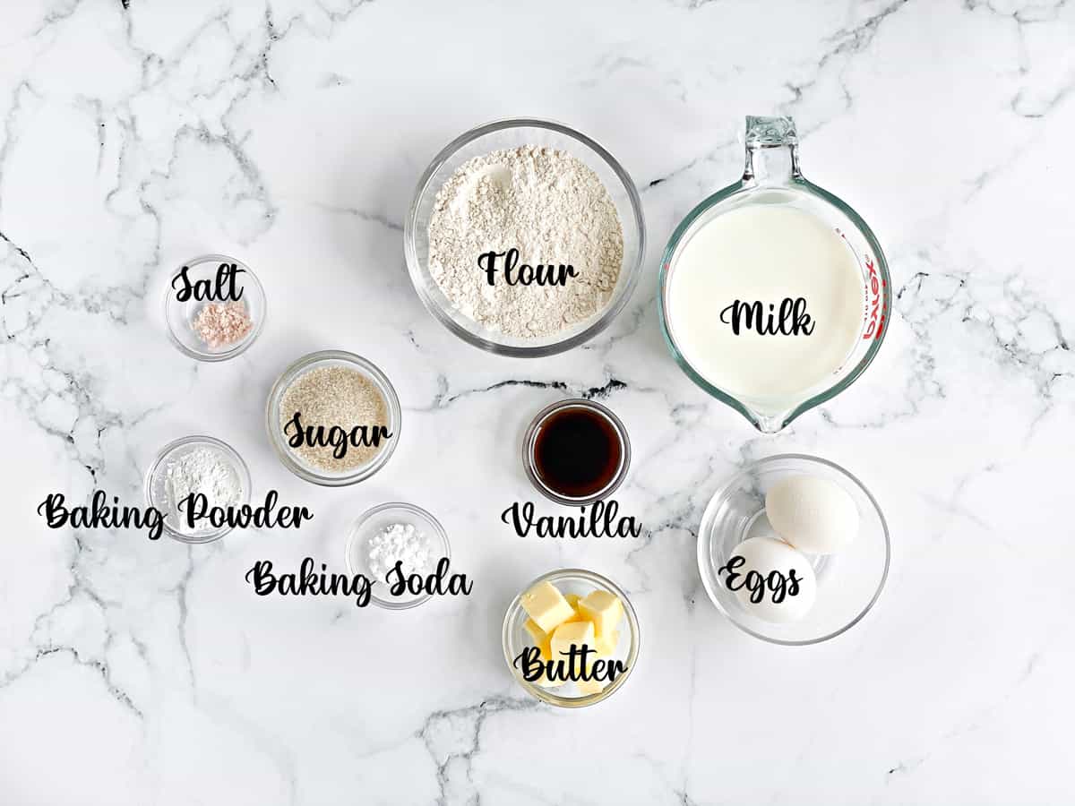 ingredients for homemade pancake recipe measured in bowls and placed on a white table