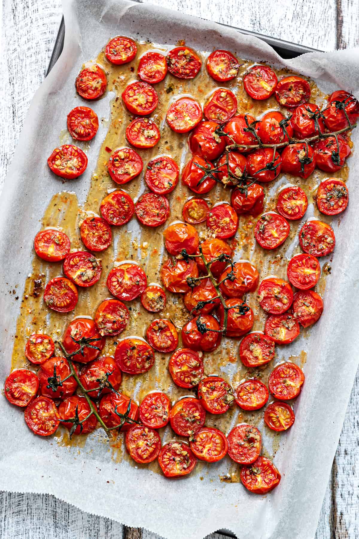 diagonal close up of oven roasted tomatoes on parchment after roasting
