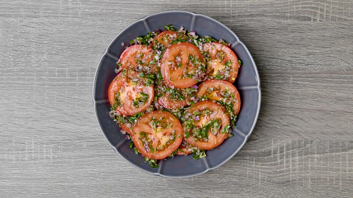 herbed marinade poured over sliced tomatoes