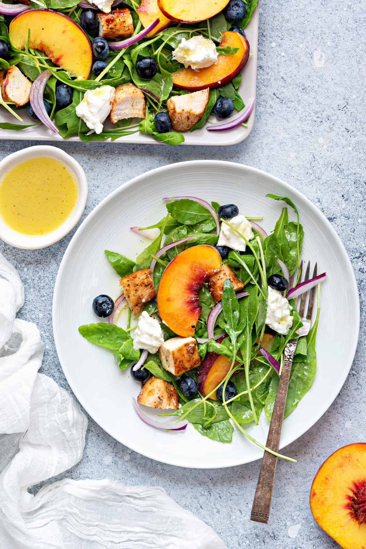 round white dinner plate with a serving of peach salad with a silver fork