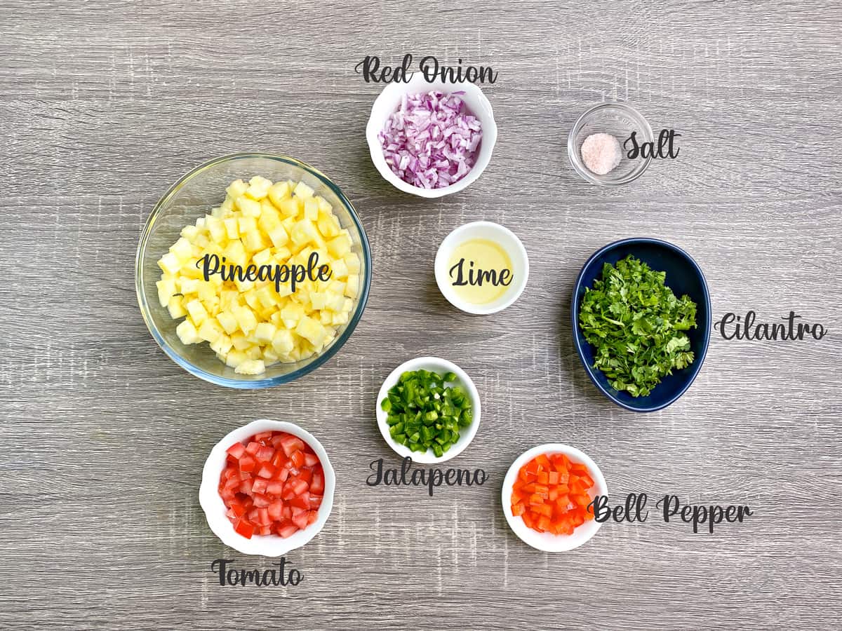 ingredients for making pineapple salsa measured out into bowls