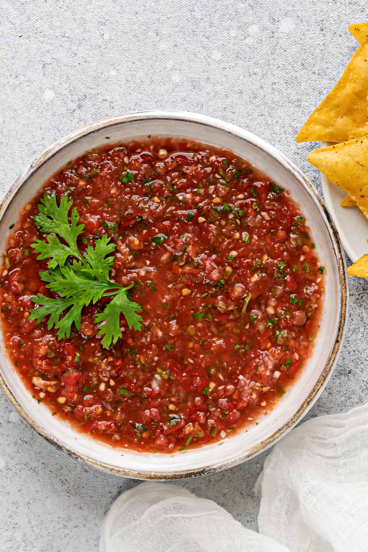 overhead shot of salsa in an earthenware bowl garnished with fresh cilantro