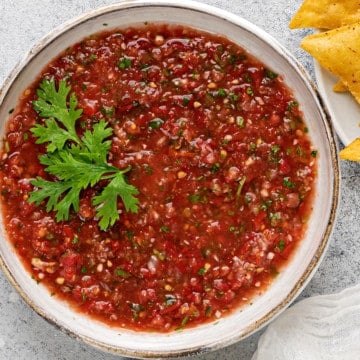 overhead shot of homemade salsa in an earthenware bowl garnished with fresh cilantro