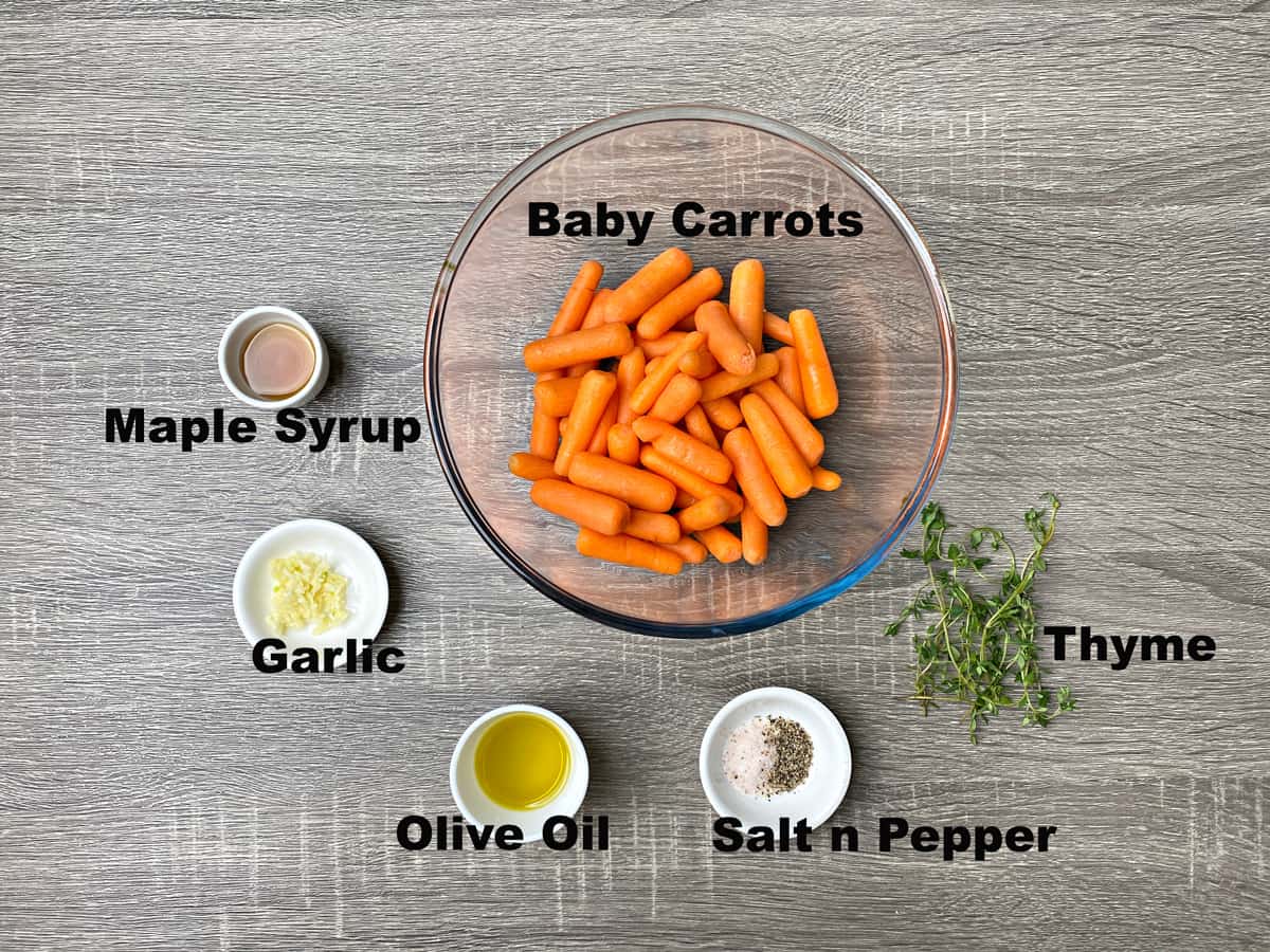 Ingredients for making thyme and maple roasted baby carrots measured out into bowls