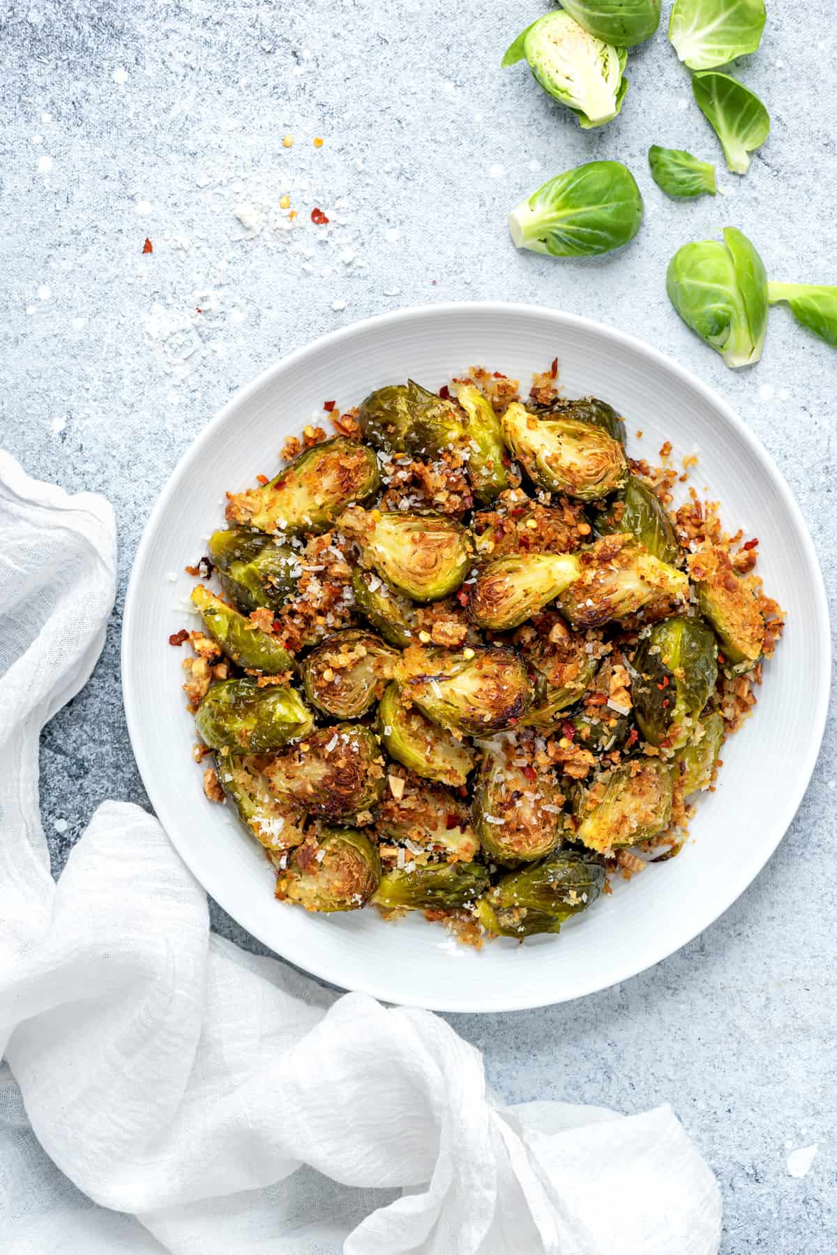 overhead shot of a round white plate filled with parmesan garlic roasted brussels sprouts