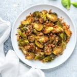 closeup of a serving platter of roasted brussels sprouts with garlic and parmesan breadcrumbs