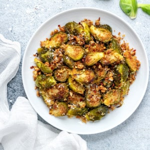 closeup of a serving platter of roasted brussels sprouts with garlic and parmesan breadcrumbs