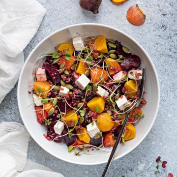 beet salad with feta, pumpkin seeds, cranberries in white bowl