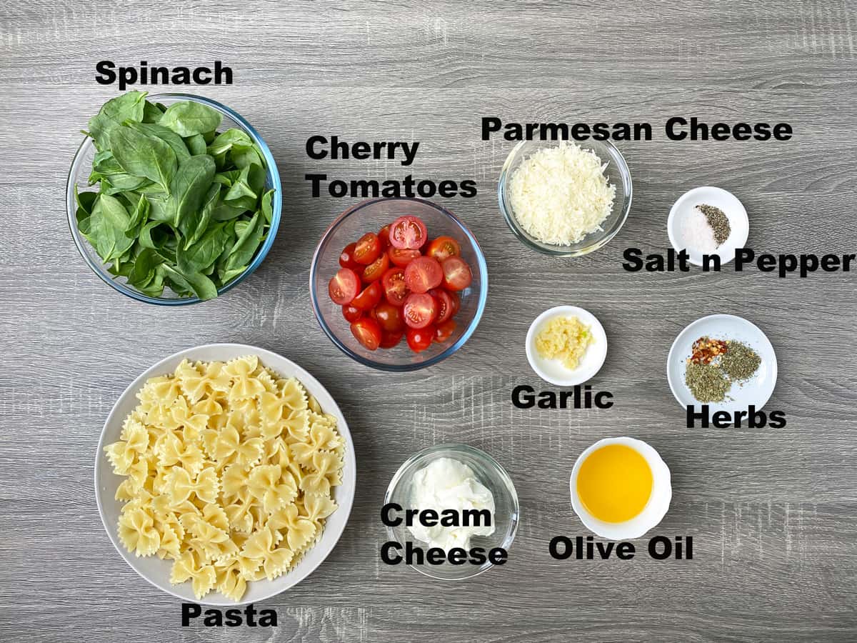 spinach, cherry tomatoes, parmesan cheese, salt, pepper, garlic, herbs, pasta, cream cheese, olive oil in bowls