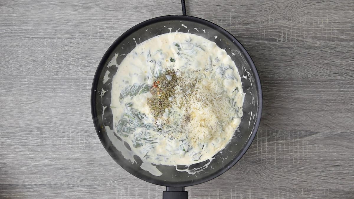 mixing seasoning and herbs into cream cheese with parmesan