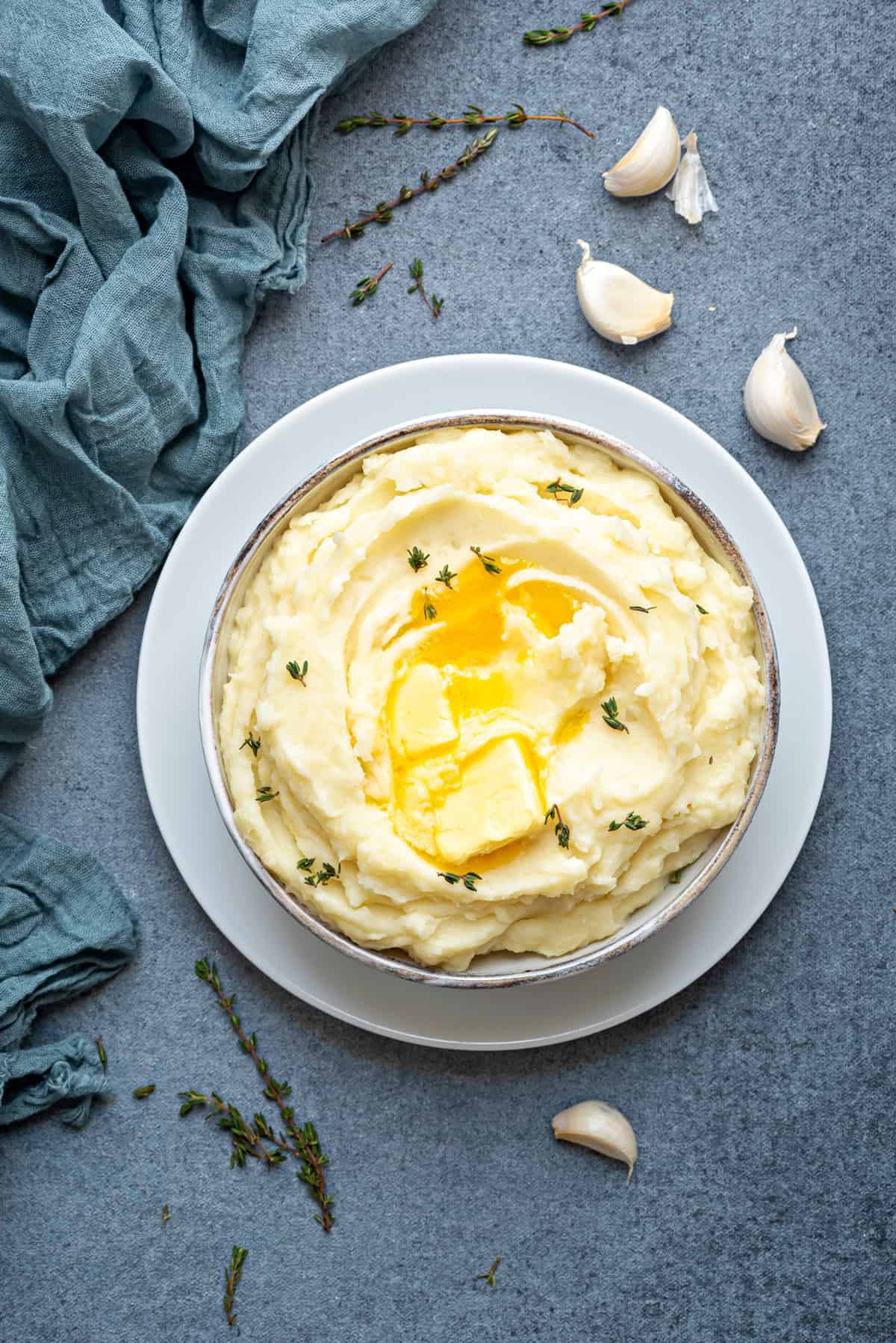 white bowl with fluffy creamy mashed potatoes with butter, garlic and herbs