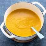 white pot filled with butternut squash soup and spoon