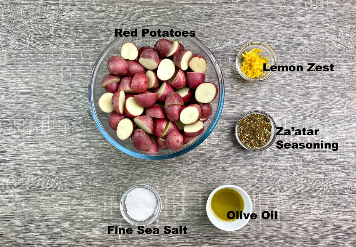 potatoes, lemon zest, za'atar seasoning, oil, sea salt in bowls kept on grey table