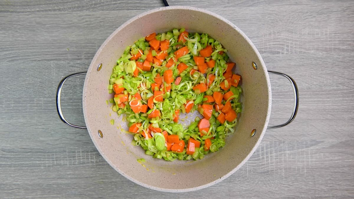 cooking vegetables in butter and garlic in pot.