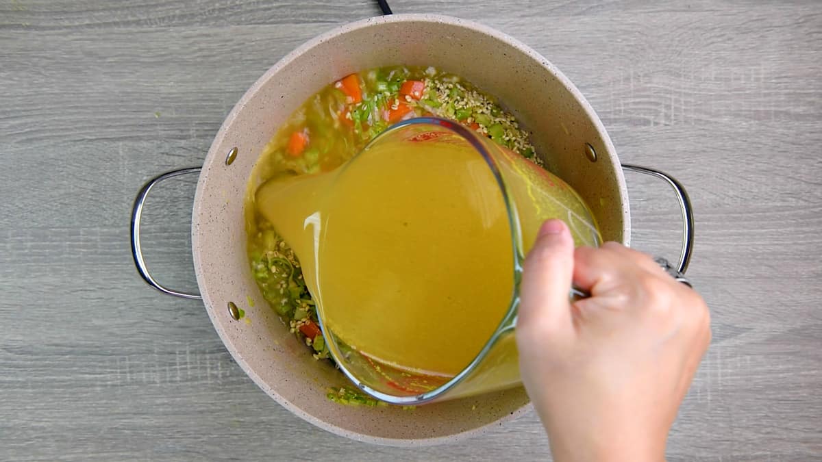 adding broth to pot.