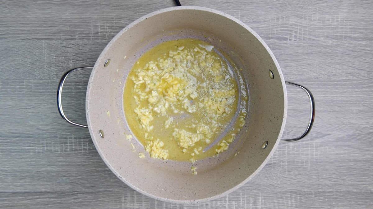 cooking garlic with melted butter in pot 