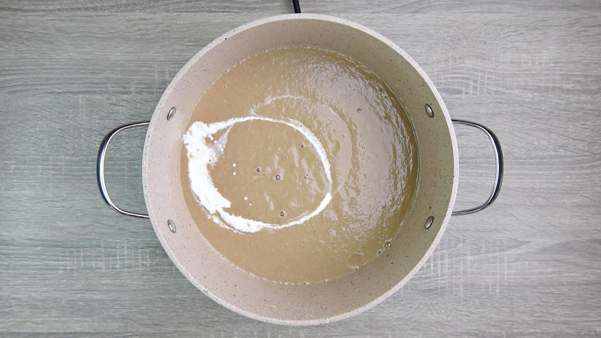 pouring cream into blended mushroom soup in pot