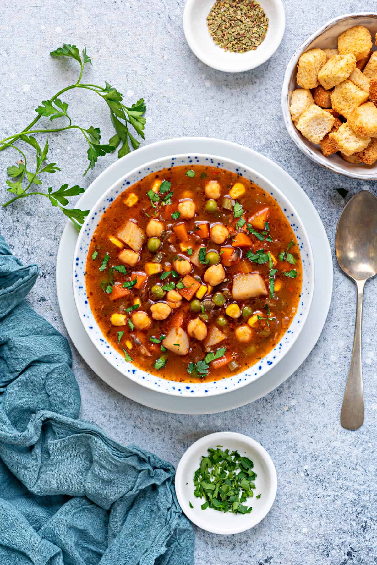 bowl filled with homemade vegetable soup kept on bluish white table