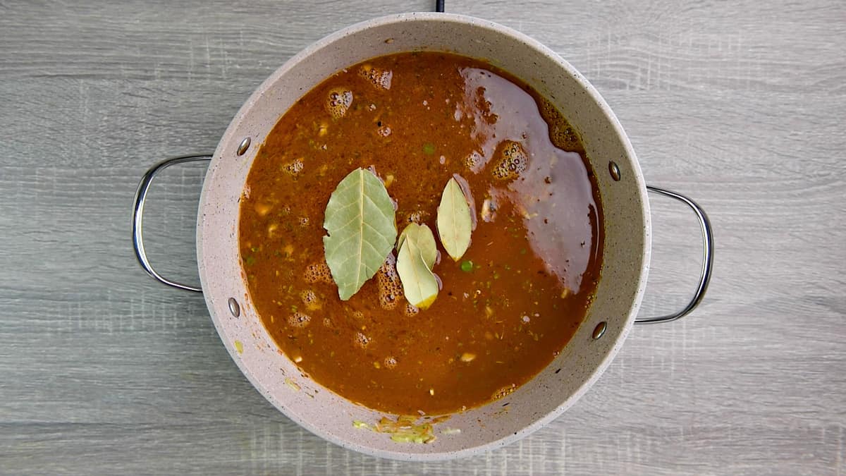 bay leaves on top of broth in Dutch oven 