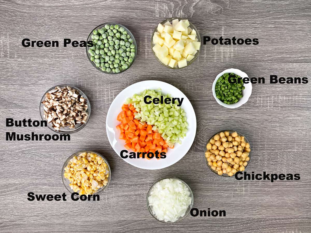 peas, potatoes, green beans, chickpeas, onion, carrots, celery, corn, mushrooms measured in glass bowls