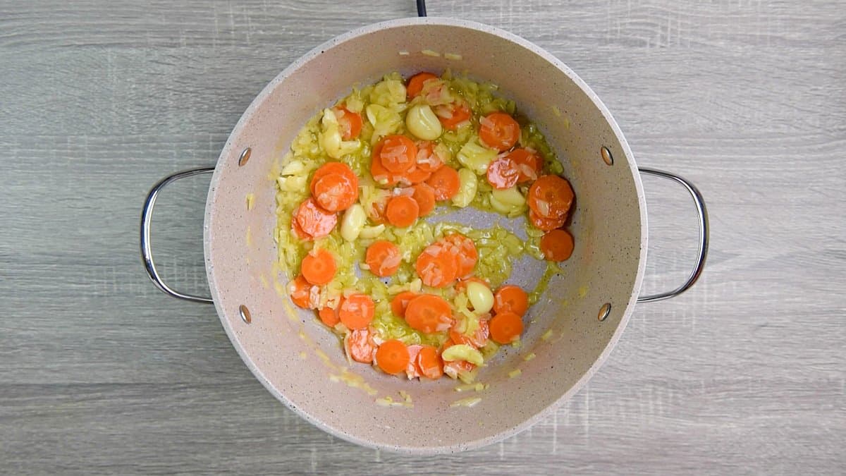 carrots sautéing in pot with butter, olive oil, onion, and garlic. 