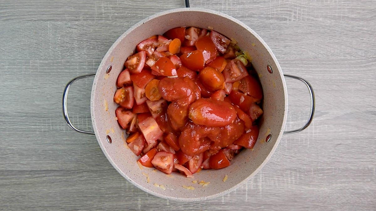 Fresh tomatoes, canned  tomatoes, salt and pepper added to the pot.