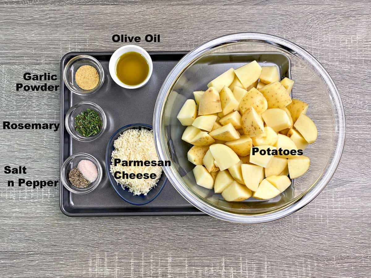 Each ingredient for rosemary roasted potatoes in individual round bowls. 