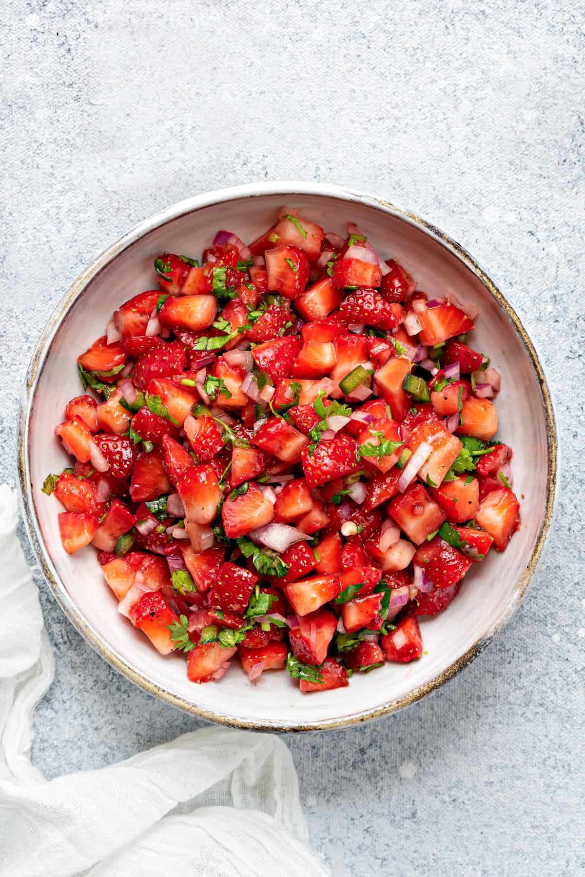 Close up shot of strawberry salsa in white serving bowl.