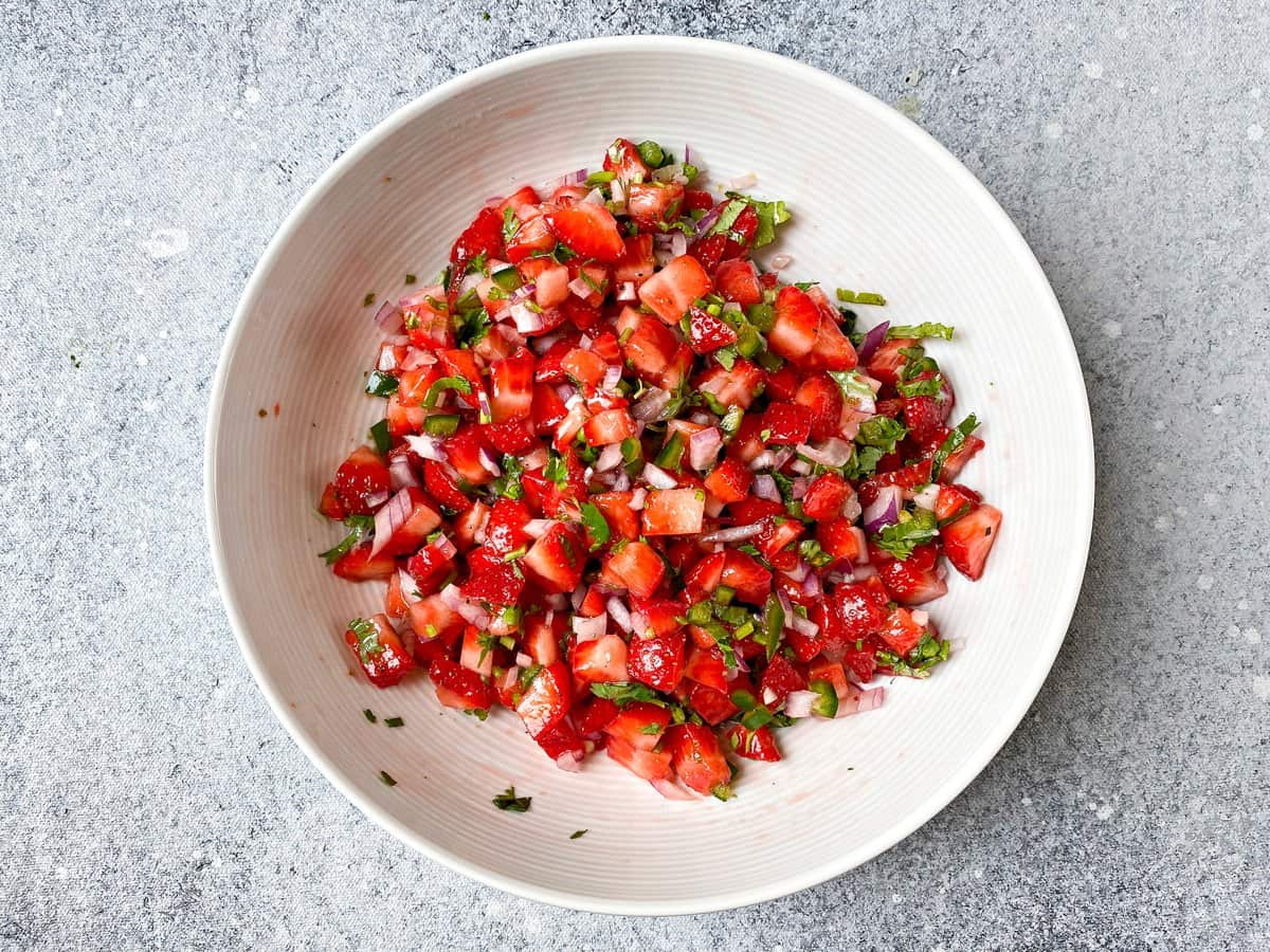 Tossed strawberry fruit salsa in white bowl, ready to serve!