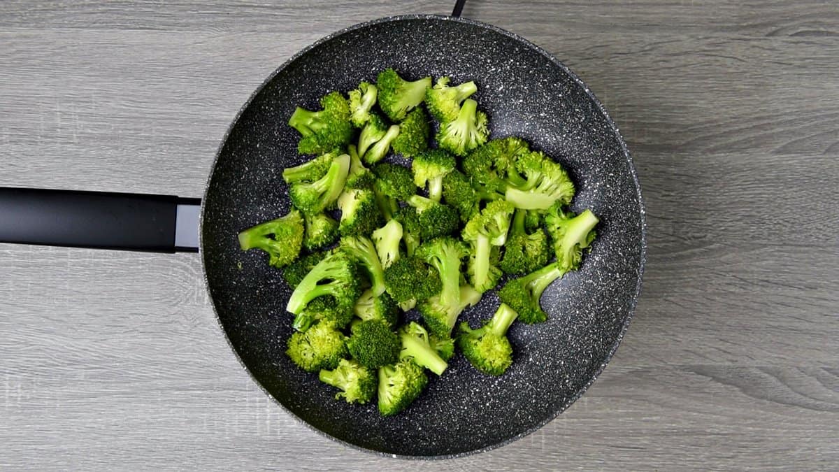 a hot skillet with sautéed broccoli florets. 