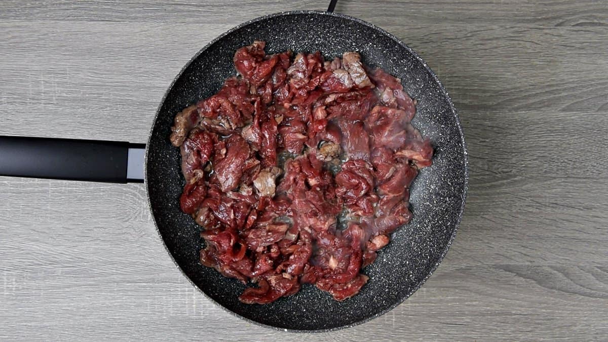 hot skillet cooking marinated beef strips until tender. 