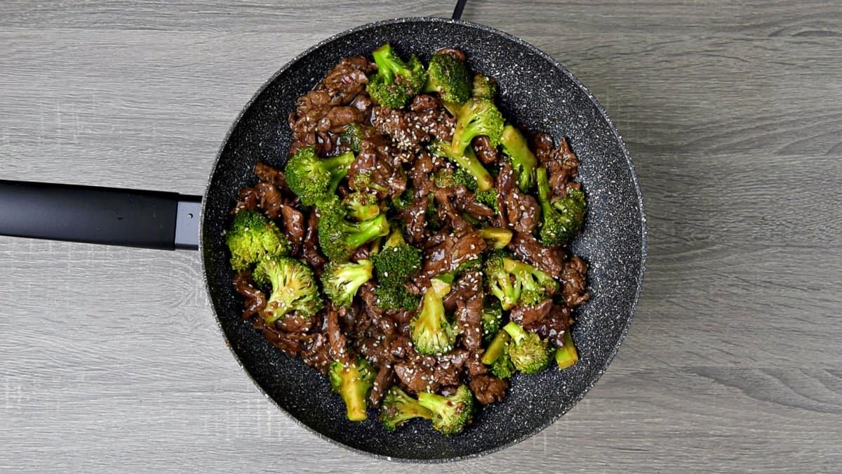 Finished beef broccoli recipe topped with sesame seeds and red chili flakes. 