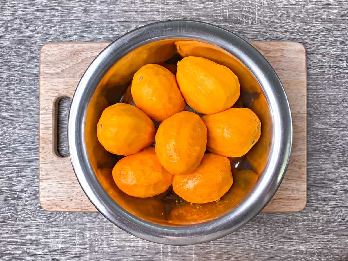 Peeled mangoes in a large bowl.