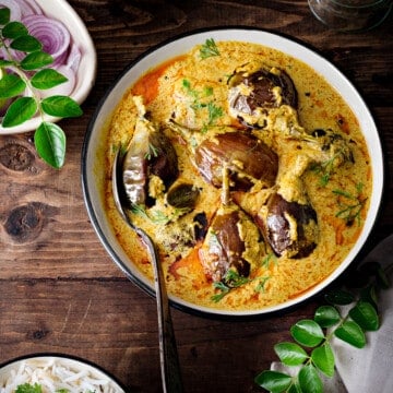Hyderabadi Bagara Baingan curry masala in a serving bowl with a spoon.