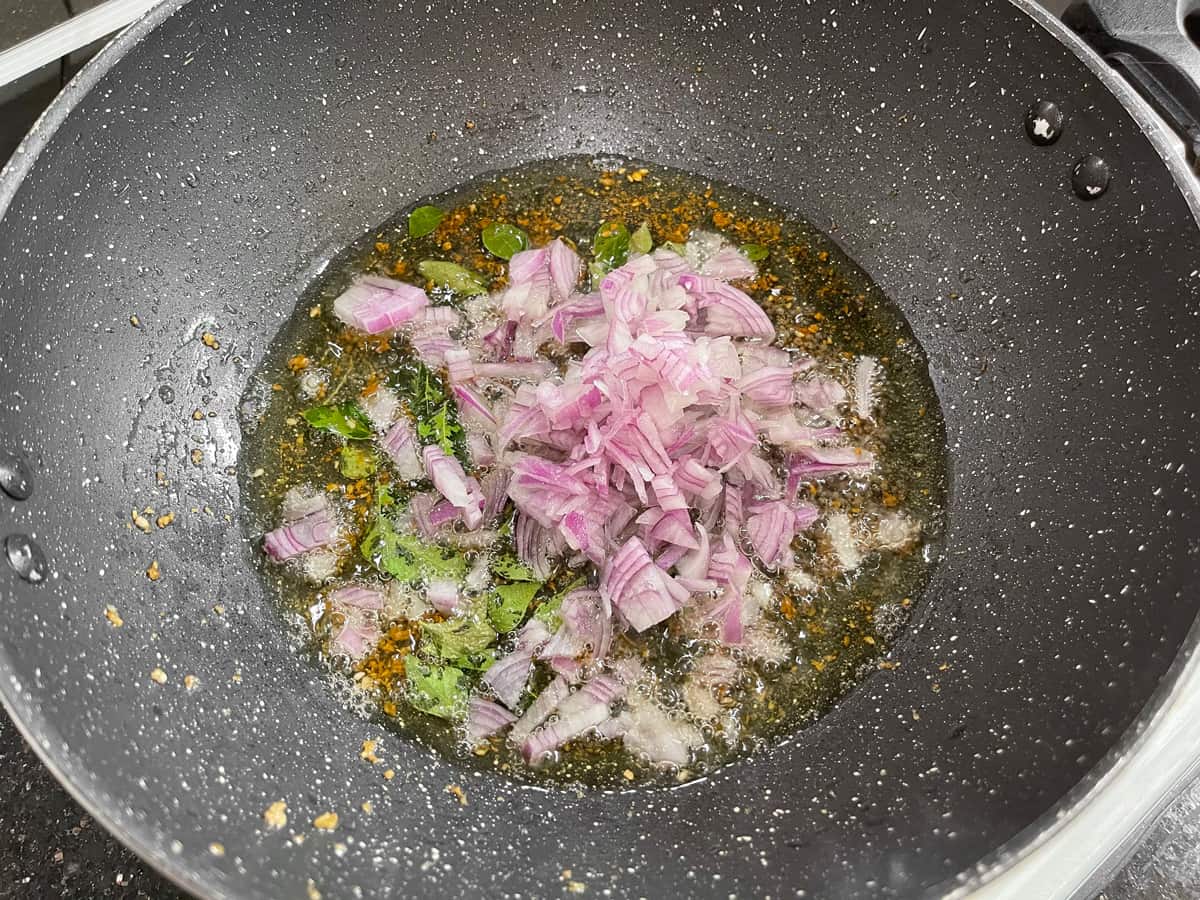 Finely chopped onion added into in the pan to fry until soft and pink.