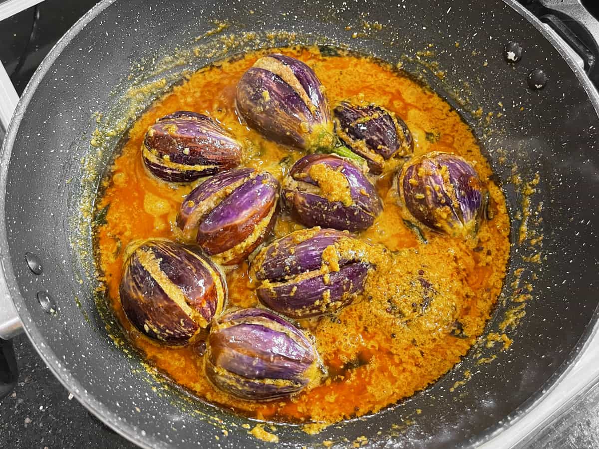 stuffed fried eggplants added to the boiling gravy in the pan.