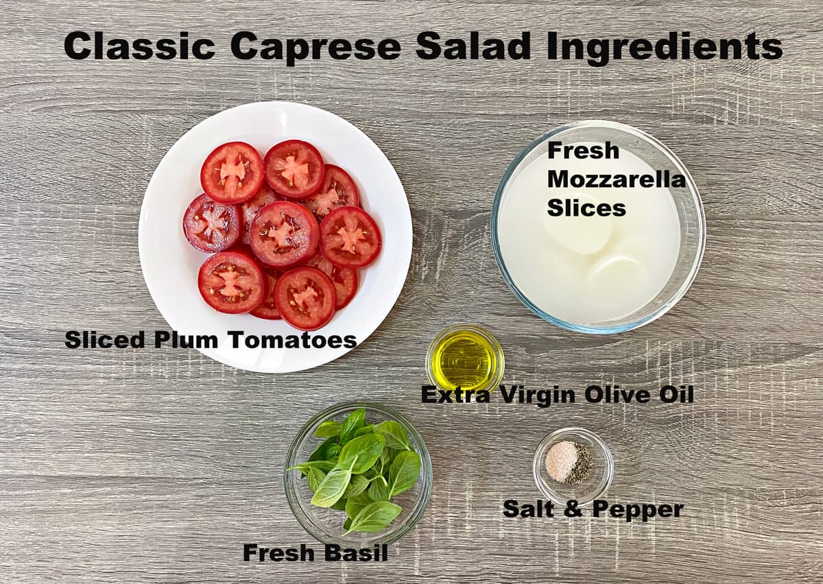 Salad ingredients in various bowls: sliced tomatoes, fresh mozzarella, olive oil, salt, pepper, and fresh basil.