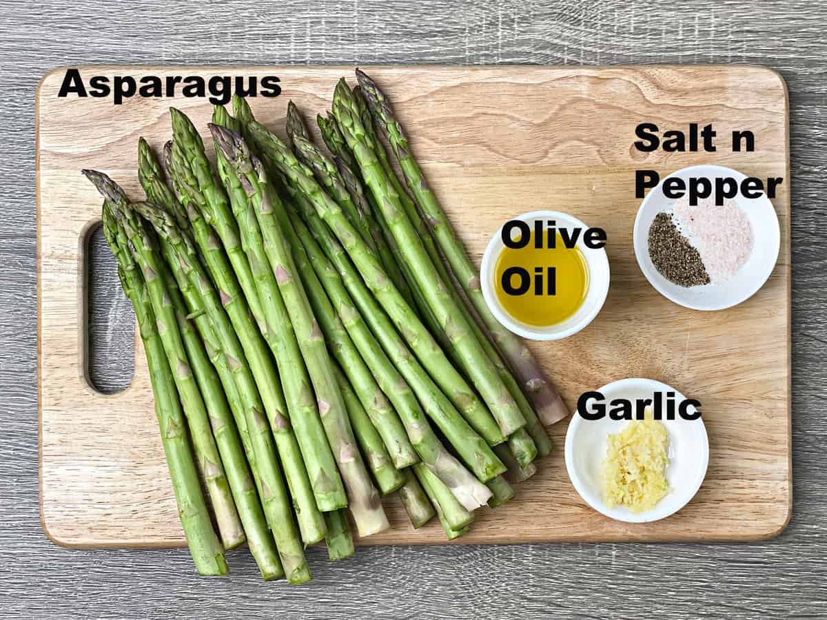Chopping board with ingredients for oven roasted asparagus recipe. 