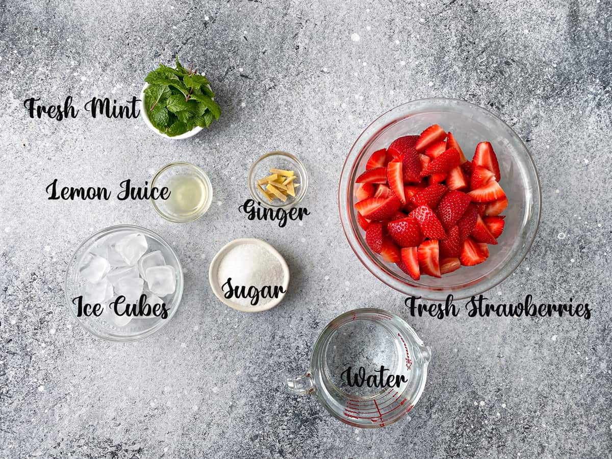 Strawberry juice ingredients  measured out in bowls and kept on a grey table.