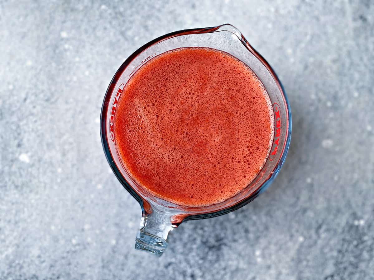 Strained strawberry juice drink in a pitcher ready to serve.