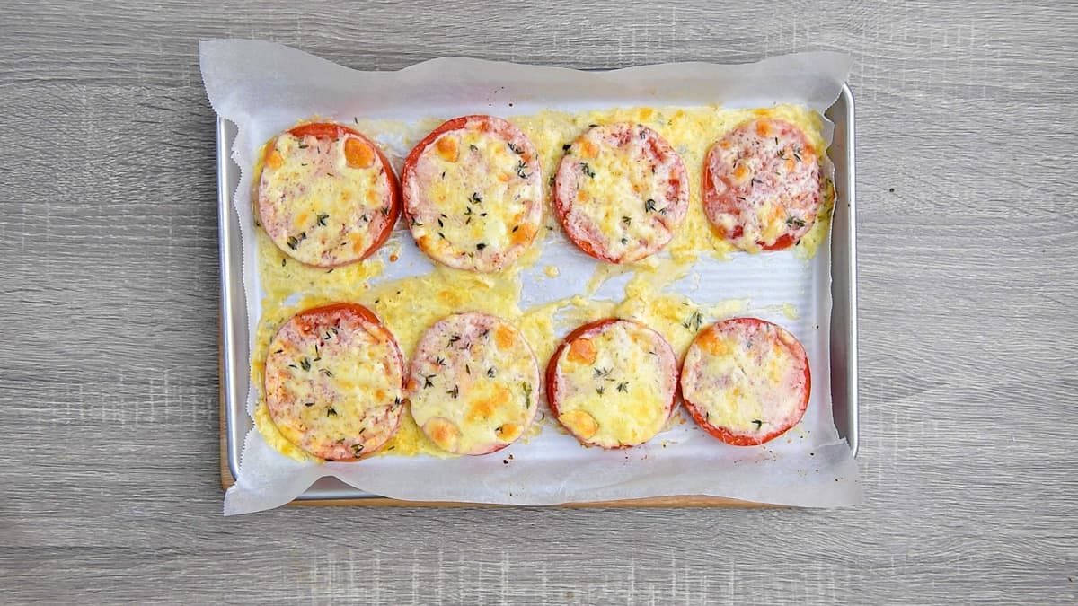 Finished shot of freshly baked tomatoes with cheese and herb is ready for serving.