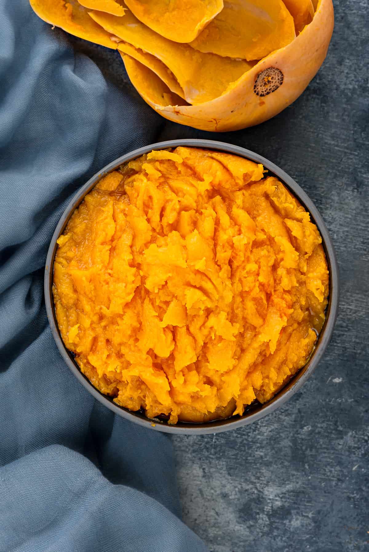 A black bowl filled with pressure cooked butternut squash mash.