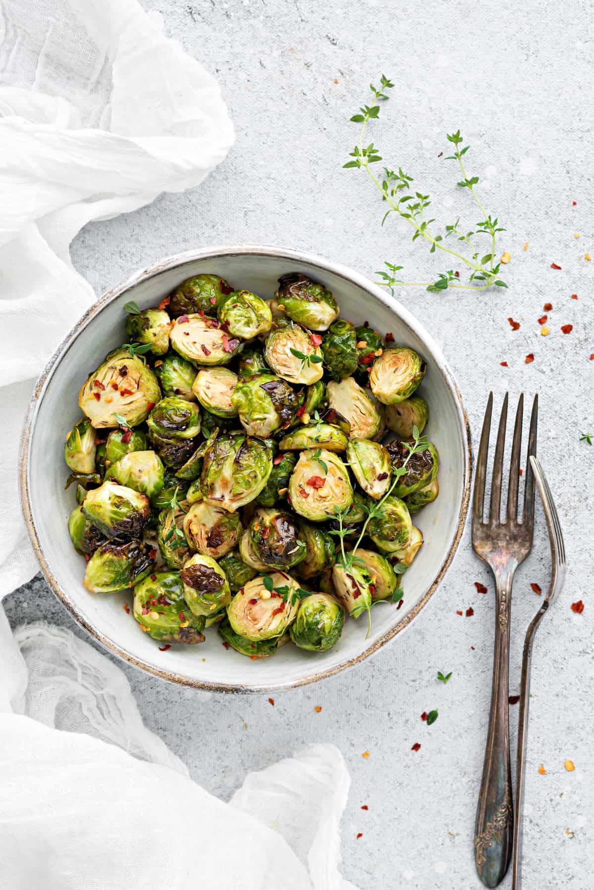 Serving of air fryer Brussels sprouts in a bowl, with two forks on the side.