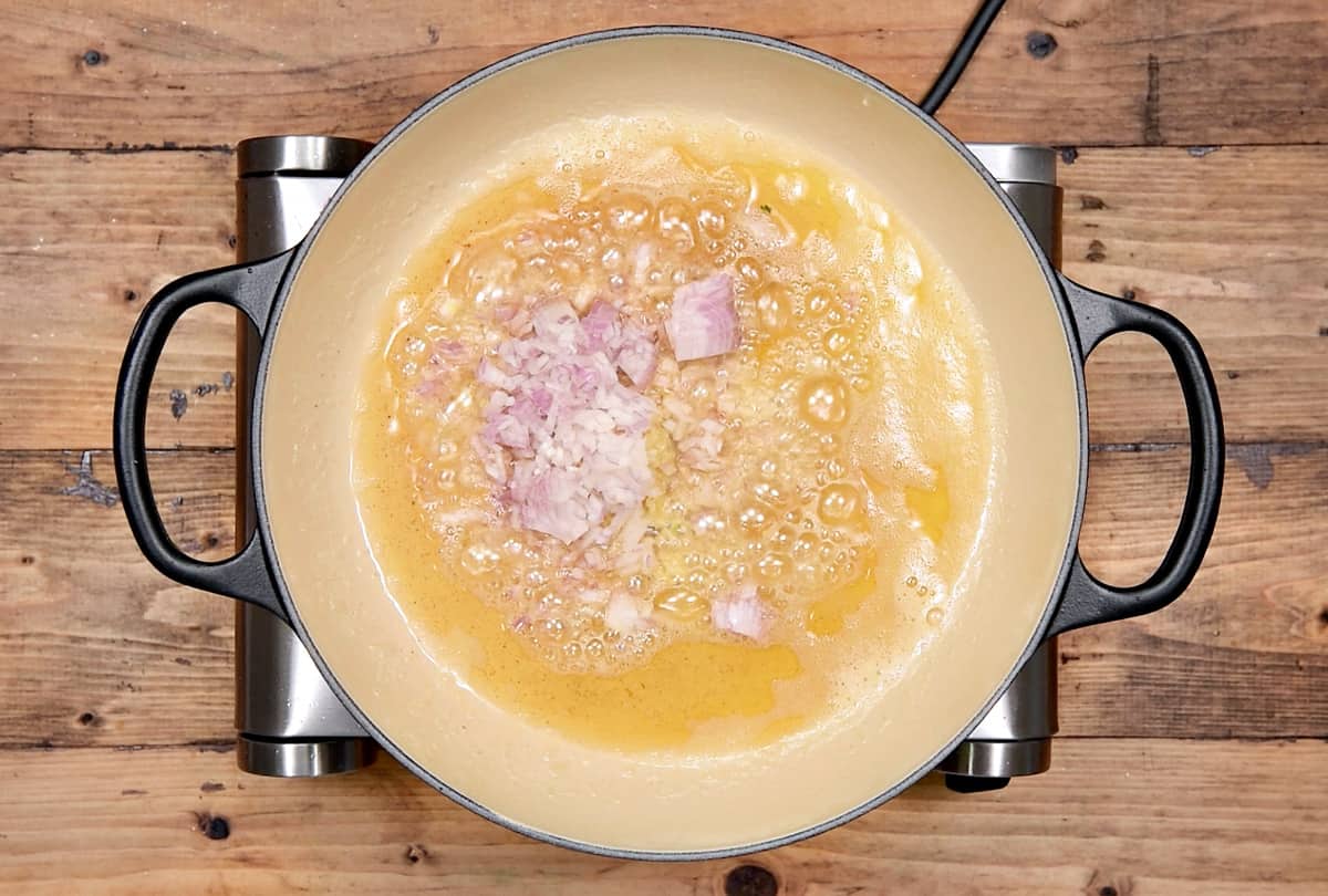 garlic and shallots added to olive and butter mixture in pot.