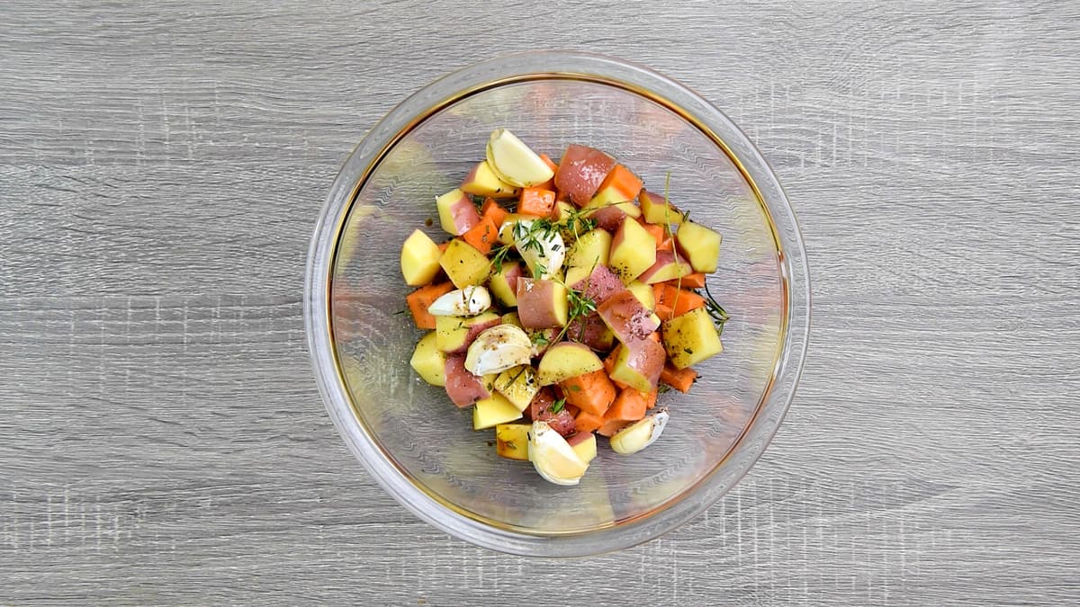 Chopped potatoes in a bowl with seasonings.