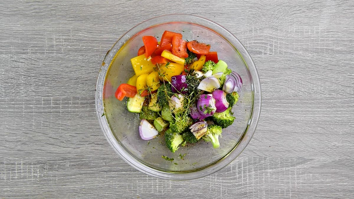 Chopped veggies in a mixing bowl with seasonings.